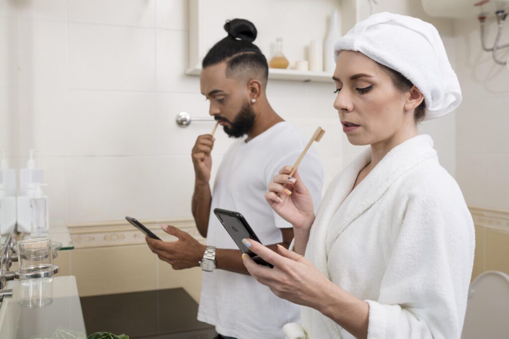 man woman checking their phones even their bathroom